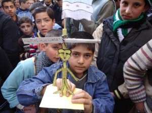 أطفال في حمص يحملون دمية تمثل شنق الرئيس السوري - موقع أخبار الثورة السورية