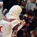 A Red Crescent volunteer offer medical care to a displaced family- Facebook