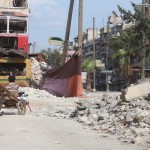 أطفال يلهون قرب أحد السواتر اللتي تحجب الرؤية عن قناص تابع للنظام السوري في حي بستان القصر