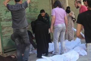 A woman searches for her child among dead bodies in Aleppo. Photo: Salah al-Ashqar