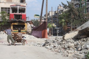 أطفال يلهون قرب أحد السواتر اللتي تحجب الرؤية عن قناص تابع للنظام السوري في حي بستان القصر