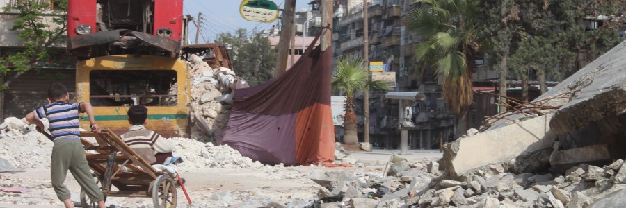 أطفال يلهون قرب أحد السواتر اللتي تحجب الرؤية عن قناص تابع للنظام السوري في حي بستان القصر