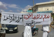 A demonstrator in Saraqeb in the province of Idlib. "We support our brethren, the free people of Qirdaha," the banner says. (Facebook - Syrians Against Sectarianism)