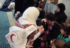 A Red Crescent volunteer offer medical care to a displaced family- Facebook