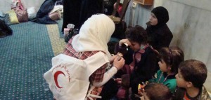 A Red Crescent volunteer offer medical care to a displaced family- Facebook