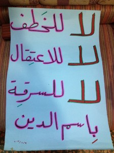 A placard written by Suad says: "No to kidnapping, no to detention, no to theft in the name of religion." Photography by Zaina Erhaim