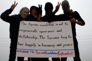 Activists in Kfar Nabel held this banner when ISIS still controlled the town. Photo credit: "Protest Banners of Occupied Kfar Nabel" page on Facebook.