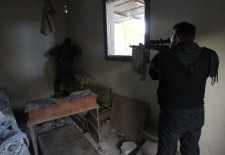 A Free Army sniper surveys the movement of regime forces in the area of Aleppo International Airport