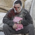 This man’s home was destroyed by a bomb on January 29 in the opposition-held Aleppo neighborhood of (neighborhood / area?). He had stepped outside his home when the bomb struck. His family was still inside. Here, he waits to see if they will be brought out alive or dead. (Al-Haj Bridge roundabout).