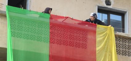 People raise the Kurdish flag on their balconies to celebrate the liberation of Kobani.