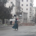 A woman passes through a checkpoint to reach her house, close to the front line in Aleppo’s Salahuddin neighbourhood. Photo: Salah al-Ashqar