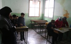 A woman teaches children drawing in the Saif al-Dawla neighbourhood of Aleppo. (Photo: Baraa al-Halabi)