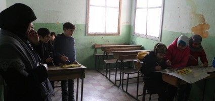 A woman teaches children drawing in the Saif al-Dawla neighbourhood of Aleppo. (Photo: Baraa al-Halabi)