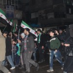A woman films a demonstration with her mobile phone. (Photo: Salah al-Ashqar)