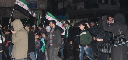 A woman films a demonstration with her mobile phone. (Photo: Salah al-Ashqar)
