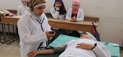 One of the trainees demonstrates how to measure blood pressure.