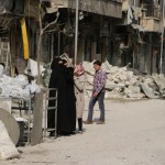 أمرأة تنظر الى منزل مهدم في حي الكلاسة