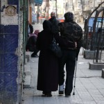 أمرأة تساعد زوجها على المشي في حي بستان القصر