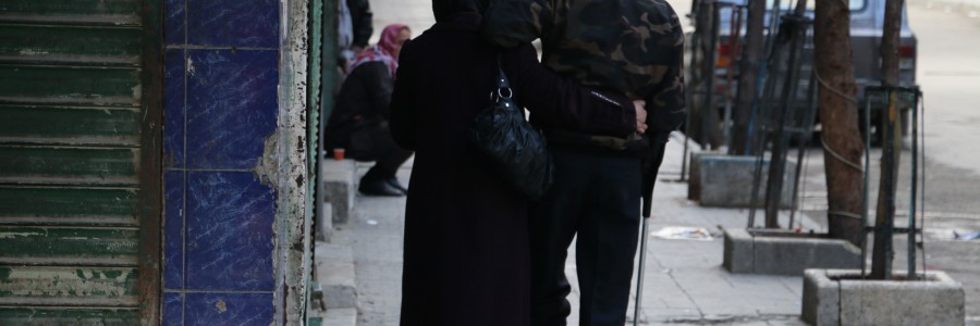 أمرأة تساعد زوجها على المشي في حي بستان القصر