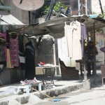 سيدة امام أحد محلات الألبسة المستعلمة في حي الزبدية في حلب. تصوير حسام كويفاتية