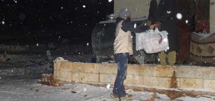Aid is distributed to camp residents on a freezing cold day