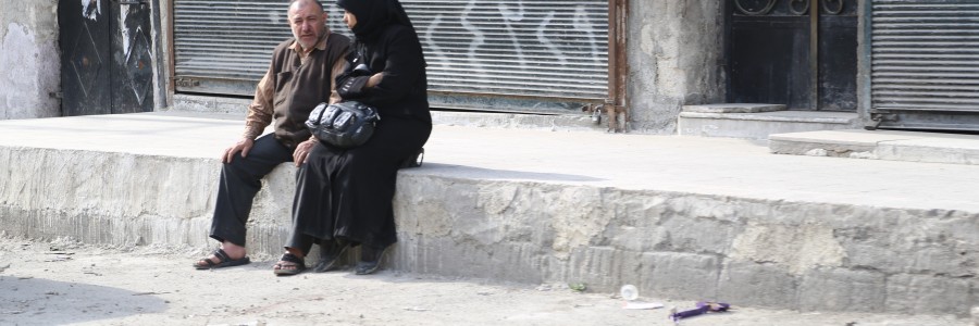 سيدة وزوجها ينتظران وسيلة نقل في حي السكري. تصوير حسام كويفاتية