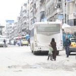 سيدة وطفلها في سوق شعبي في حي الشعار في حلب. تصوير حسام كويفاتية