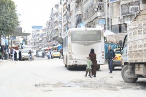 سيدة وطفلها في سوق شعبي في حي الشعار في حلب. تصوير حسام كويفاتية