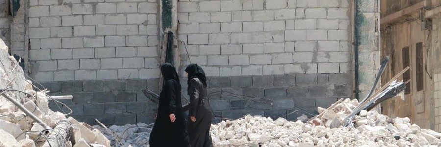 نساء يمشين في حي المعادي بين ركام القصف. تصوير براء الحلبي