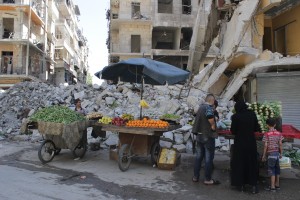 A woman buys vegetables from a street vendor in Aleppo’s Al-Shaar neighbourhood. Photo: Baraa al-Halabi