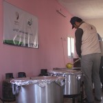 Young men busy cooking in a field kitchen