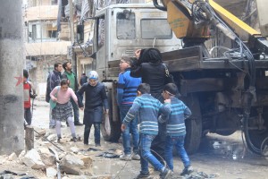 A woman and her children inspect their bombed-out house in Aleppo’s Al-Mashad neighbourhood. Photo: Salah al-Ashqar